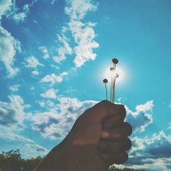 Low angle view of hand holding blue sky