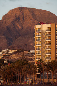 Building by sea against mountain range