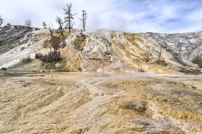 Scenic view of landscape at mammoth hot springs against sky