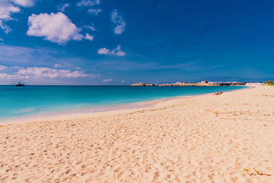 Scenic view of beach against blue sky