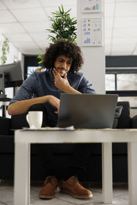 Young woman using laptop at table