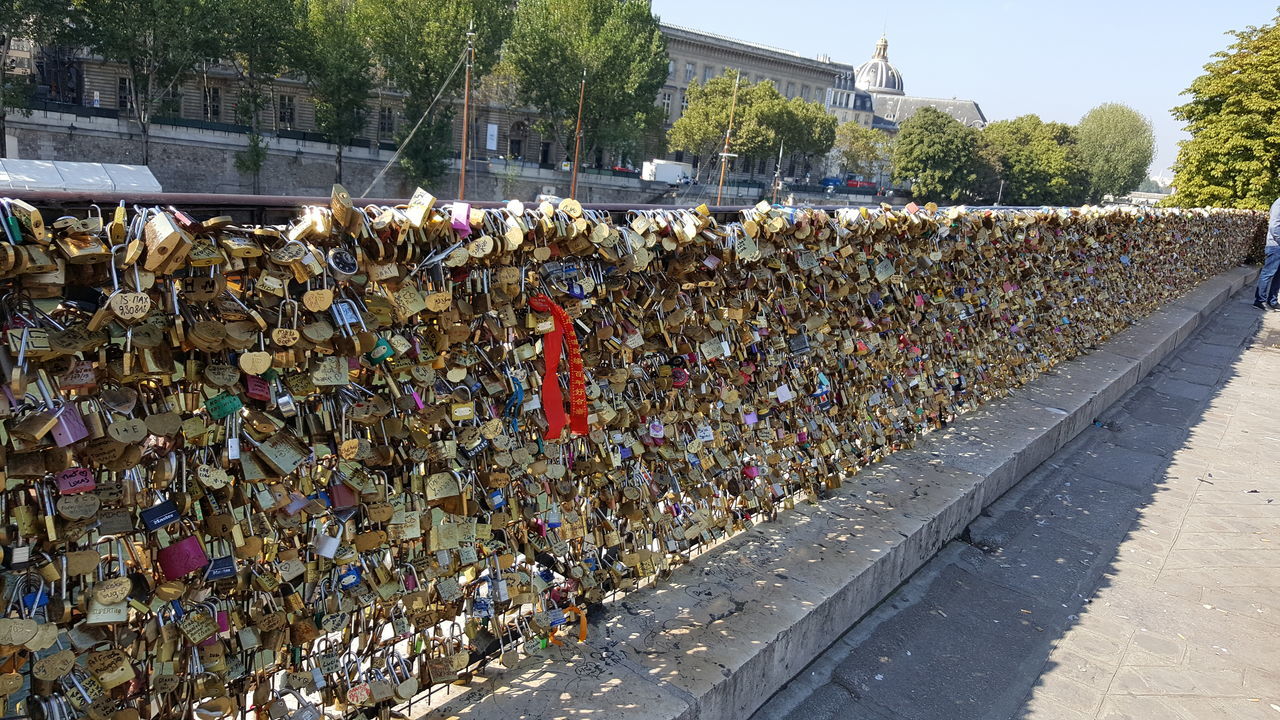 CLOSE-UP OF PADLOCKS AGAINST BRIDGE