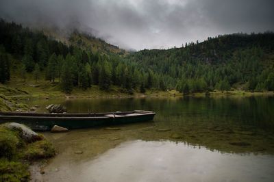 Scenic view of lake by trees against sky