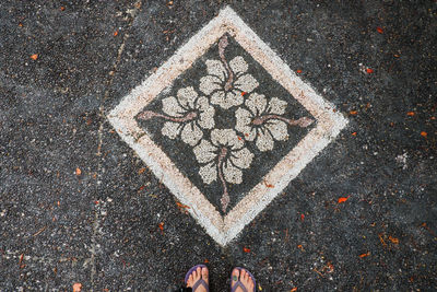 Low section of man standing by rangoli on road