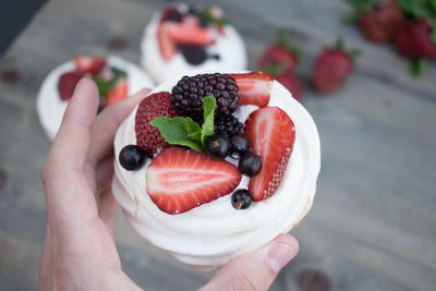 Cropped hand holding dessert over table