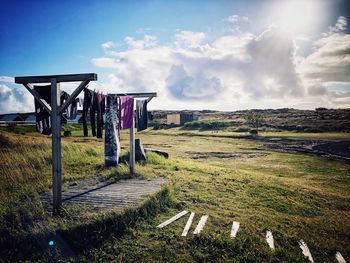 Clothes drying on field against sky