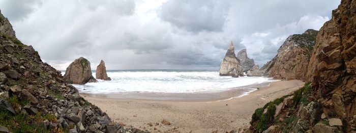 Panoramic view of rocks on beach against sky