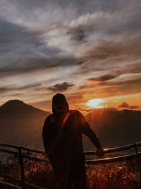 Rear view of man looking at sunset