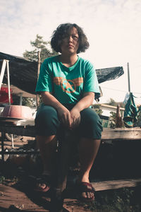 Full length of woman looking at while sitting on seat