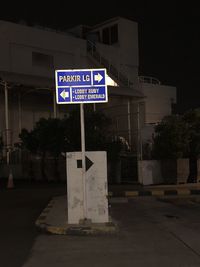 Road sign on street in city at night
