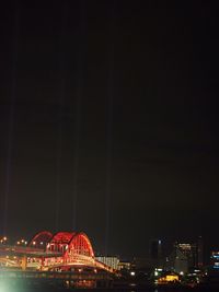 Illuminated ferris wheel in city at night