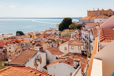 High angle view of townscape by sea against sky