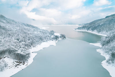 Aerial view of lake and mountain forest in winter