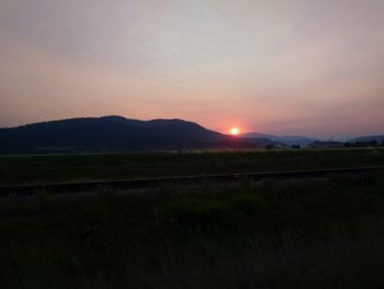 Scenic view of field against sky during sunset