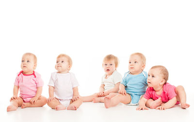 Portrait of siblings playing with toy blocks against white background