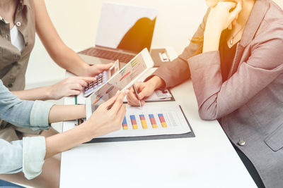 Midsection of woman using mobile phone on table