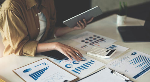 Midsection of businesswoman working on table