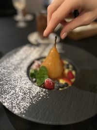 Cropped hand of person preparing food on table