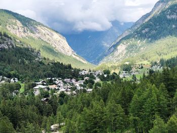 Scenic view of townscape and mountains against sky