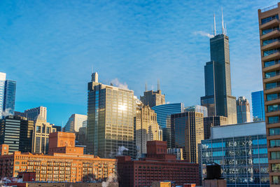 Low angle view of modern cityscape against sky