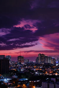 Illuminated buildings against sky at night