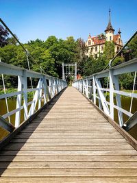 Footbridge leading to bridge against sky