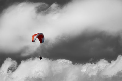 Low angle view of person paragliding against sky