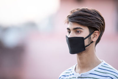 Portrait of young man covering face