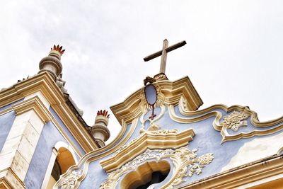 Low angle view of statues on building against sky