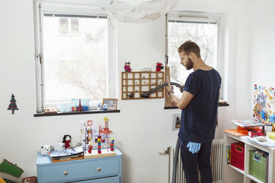 Man vacuuming small shelves