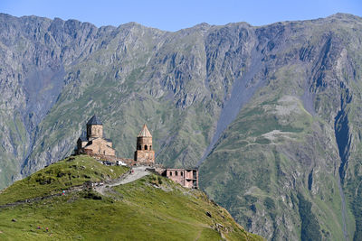 Panoramic view of gergeti trinity church against the mountains.