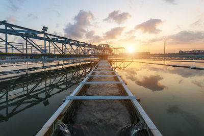 Bridge over river against sky during sunset