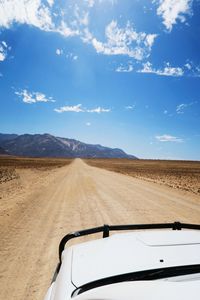 Road by desert against sky