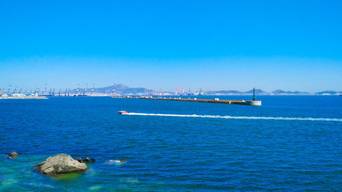 Scenic view of sea against clear blue sky