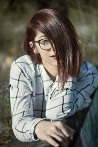 Beautiful young woman sitting outdoors