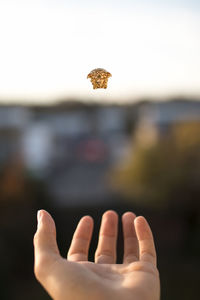 Close-up of hand against sky