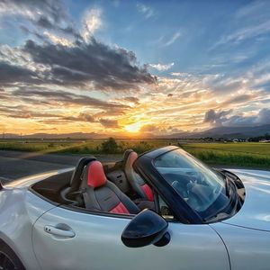 Car on road against sky during sunset