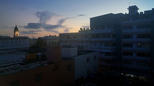 Silhouette built structures against sky at dusk