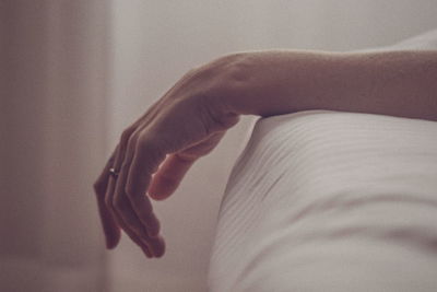 Close-up of woman hand on bed