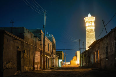 Low angle view of illuminated buildings against sky at night