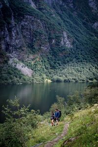 People on lake against mountain