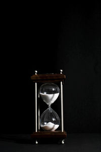 Close-up of hourglass against black background