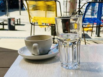 Close-up of coffee cup on table with glass of water