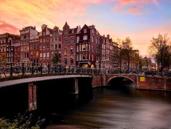 Bridge over river in city against sky
