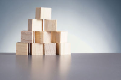 Close-up of wooden toy blocks on table against wall