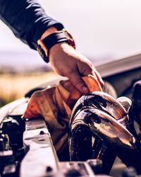 Cropped hand of mechanic cleaning car engine