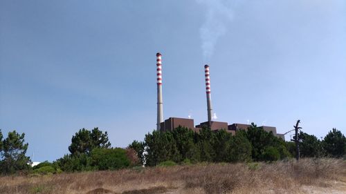 Low angle view of factory against clear blue sky