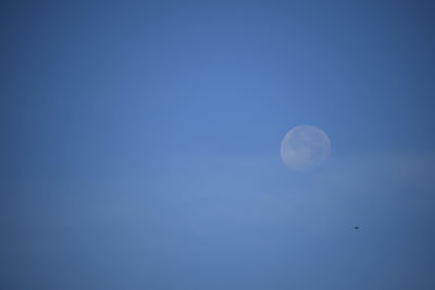 Low angle view of moon against blue sky