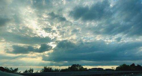 Silhouette of trees against cloudy sky