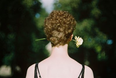 Rear view of woman with pink flower